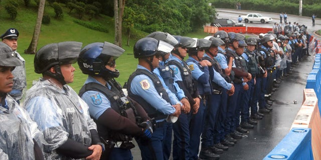 Police officers form a barrier against Puerto Ricans protesting the creation of a federal control board in Fajardo, Puerto Rico, Friday, Nov. 18, 2016. The board is charged with overseeing Puerto Rico's finances amid a dire economic crisis and is meeting for the first time in the U.S. territory. (AP Photo/Danica Coto)