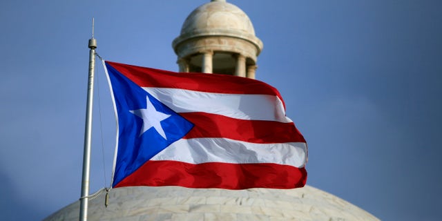 FILE - In this July 29, 2015 file photo, the Puerto Rican flag flies in front of Puerto Rico's Capitol as in San Juan, Puerto Rico. The White House plans to announce the members of a new oversight board to help manage Puerto Rico's debt-stricken economy. Legislation passed in June set up the control board and required the White House to choose from a list recommended by congressional leaders by September. (AP Photo/Ricardo Arduengo, File)