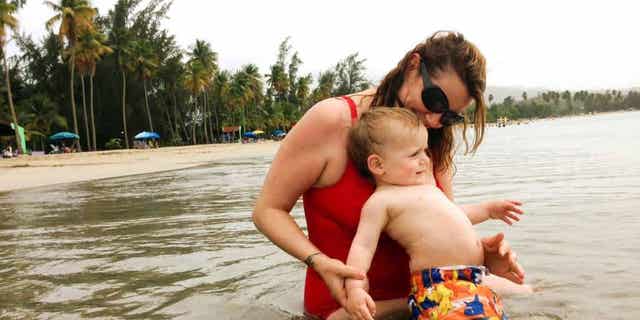 In this May 23, 2015 photo, Amber Hunt plays with her 17-month-old son Hunt Van Benschoten at a beach in San Juan, Puerto Rico. No matter how experienced a traveler you are, an overseas trip taken with a baby or toddler requires changes in planning, expectations and itineraries. (Elijah Van Benschoten via AP)