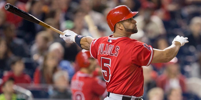 Los Angeles Angels Albert Pujols watches the ball after connecting for a two-run homer against Washington Nationals Taylor Jordan in the fifth inning of a baseball game in Washington, Tuesday, April 22, 2014. This was Pujols 500th career home run. (AP Photo/Pablo Martinez Monsivais)