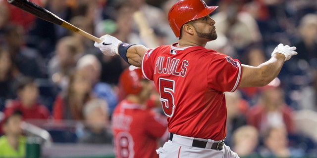 Los Angeles Angels Albert Pujols watches the ball after connecting for a two-run homer against Washington Nationals Taylor Jordan in the fifth inning of a baseball game in Washington, Tuesday, April 22, 2014. This was Pujols 500th career home run. (AP Photo/Pablo Martinez Monsivais)