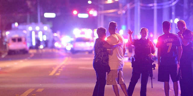 Orlando Police officers direct family members away from a multiple shooting at a nightclub in Orlando, Fla., Sunday, June 12, 2016. A gunman opened fire at a nightclub in central Florida, and multiple people have been wounded, police said Sunday. (AP Photo/Phelan M. Ebenhack)