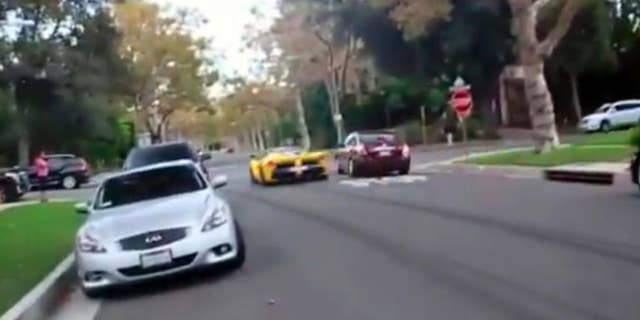 This frame grab from a video shows a yellow Ferrari speeding through a stop sign, Thursday, Sept. 17, 2015, in Beverly Hills, Calif. A Middle Eastern sheikh who allegedly said he owned a Ferrari caught on film speeding through a Beverly Hills neighborhood apparently has raced out of town, police said Thursday. Khalid bin Hamad Al Thani of Qatar has left the country and the cars are gone, authorities said at a news conference. (AP Photo)