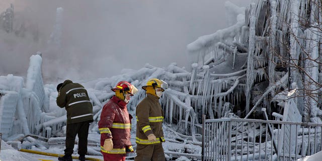 Jan. 23, 2014 - Police and firefighters survey the damage after a fatal fire at a seniors residence in L'Isle-Verte, Quebec. The fire raged through the seniors residence, killing at least 5 people and leaving about 30 unaccounted for.