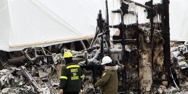 January 25, 2014: Emergency workers continue the search for victims  in L'Isle-Verte, Quebec, at the scene of Thursday's fatal fire at a seniors residence. (AP Photo/The Canadian Press, Ryan Remiorz)