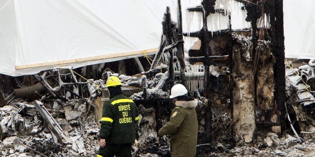 January 25, 2014: Emergency workers continue the search for victims in L'Isle-Verte, Quebec, at the scene of Thursday's fatal fire at a seniors residence. (AP Photo/The Canadian Press, Ryan Remiorz)