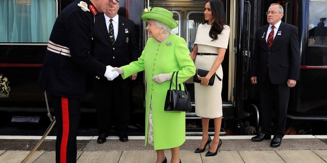 Britain's Queen Elizabeth II and Meghan, the Duchess of Sussex, arrive by Royal Train at Runcorn Station, northwest England.