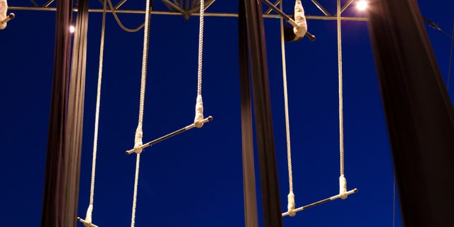 Empty standing trapezes against dark blue sky at twilight