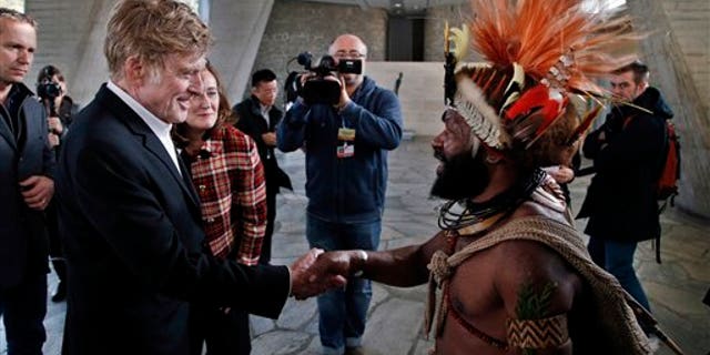 Chief of the Huli tribe in Papua New-Guinea, Mundiya Kepanga, right, shakes hands with actor and environmental activist Robert Redford, prior to a conference on climate, at the UNESCO headquarters, in Paris, Sunday, Dec. 6, 2015.(AP Photo/Thibault Camus)