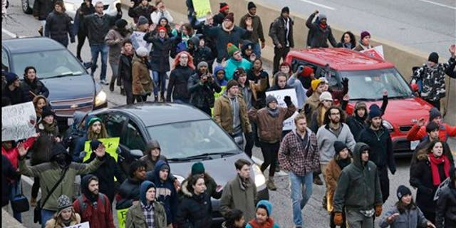 In this Nov. 25, 2014, photo, protesters block cars on the freeway during a protest over the police shooting of Tamir Rice in Cleveland. (AP Photo/Tony Dejak, File)
