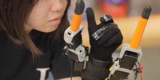 MIT graduate student, Faye Wu, demonstrates the new robotic device.