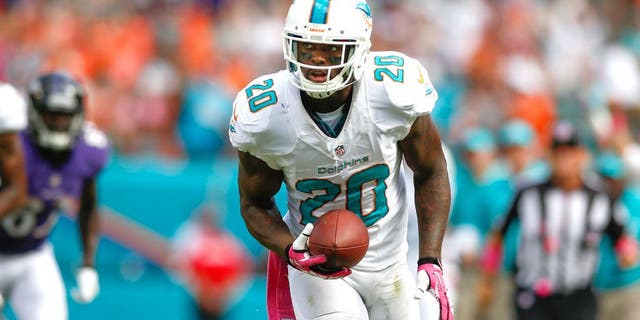 Oct 6, 2013; Miami Gardens, FL, USA; Miami Dolphins free safety Reshad Jones (20) returns am interception for a touchdown against the Baltimore Ravens in the second half at Sun Life Stadium. Mandatory Credit: Robert Mayer-USA TODAY Sports