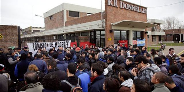 Workers outside the entrance of RR Donnelley printing plant in the outskirts of Buenos Aires, Argentina, Aug. 11, 2014.