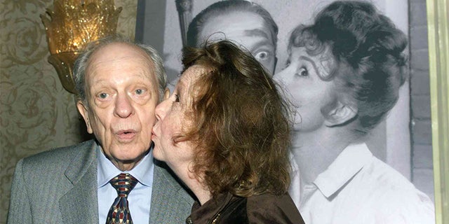 Actor Don Knotts is kissed by actress Betty Lynn who portrayed Fife's girlfriend Thelma as they recreate a pose from a publicity photograph in this January 19, 2000 file photo.