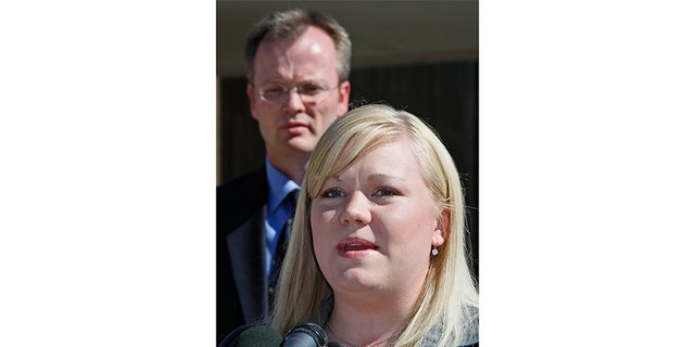 Washington County Attorney Brock Belnap watches as Elissa Wall (R) talks to the media outside Utah's 5th Judicial District Courthouse in St. George September 25, 2007, after U.S. polygamist sect leader Warren Jeffs was convicted of being an accomplice to rape for arranging a marriage between an unwilling 14-year-old girl, Wall, and her 19-year-old first cousin. Jeffs faces five years to life in prison for each of the two felony charges of accomplice to rape. No date was set for sentencing.