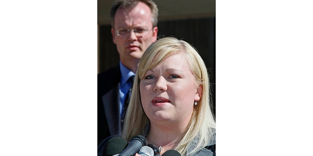 Washington County Attorney Brock Belnap watches as Elissa Wall (R) talks to the media outside Utah's 5th Judicial District Courthouse in St. George September 25, 2007, after U.S. polygamist sect leader Warren Jeffs was convicted of being an accomplice to rape for arranging a marriage between an unwilling 14-year-old girl, Wall, and her 19-year-old first cousin. Jeffs faces five years to life in prison for each of the two felony charges of accomplice to rape. No date was set for sentencing.
