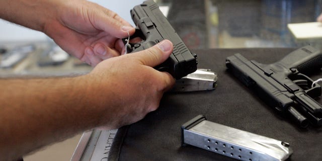 June 26, 2008 file A customer inspects a 9mm handgun at Rink's Gun and Sport in the Chicago, suburb of Lockport, Illinois