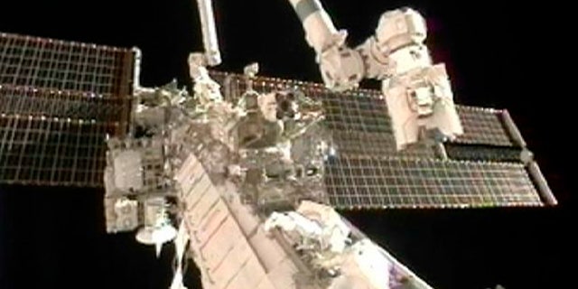 Doug Wheelock (top) and Tracy Caldwell Dyson work to remove a faulty ammonia pump module on the exterior of the International Space Station during their spacewalk in this image from NASA TV August 7, 2010.     REUTERS/NASA TV  (UNITED STATES) EDITORIAL USE ONLY NOT FOR USE IN ADVERTISING OR MARKETING CAMPAIGNS (SCI TECH SOCIETY) FOR EDITORIAL USE ONLY. NOT FOR SALE FOR MARKETING OR ADVERTISING CAMPAIGNS