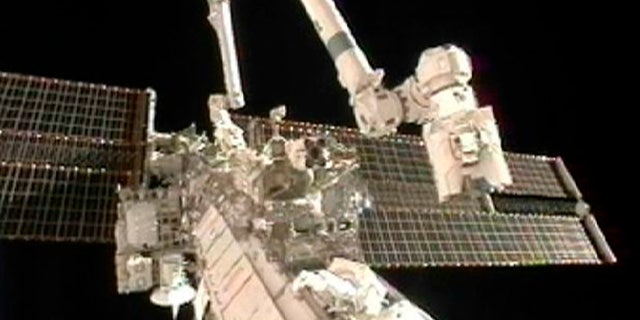 Doug Wheelock (top) and Tracy Caldwell Dyson work to remove a faulty ammonia pump module on the exterior of the International Space Station during their spacewalk in this image from NASA TV August 7, 2010. REUTERS/NASA TV (UNITED STATES) EDITORIAL USE ONLY NOT FOR USE IN ADVERTISING OR MARKETING CAMPAIGNS (SCI TECH SOCIETY) FOR EDITORIAL USE ONLY. NOT FOR SALE FOR MARKETING OR ADVERTISING CAMPAIGNS