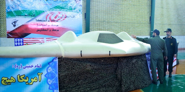 Undated photo (received by Reuters from Iran's Sepha News December 8, 2011) shows a member of Iran's revolutionary guard pointing at a U.S. RQ-170 unmanned spy plane as he speaks with Amirali Hajizadeh (R), a revolutionary guard commander, at an unknown location in Iran.