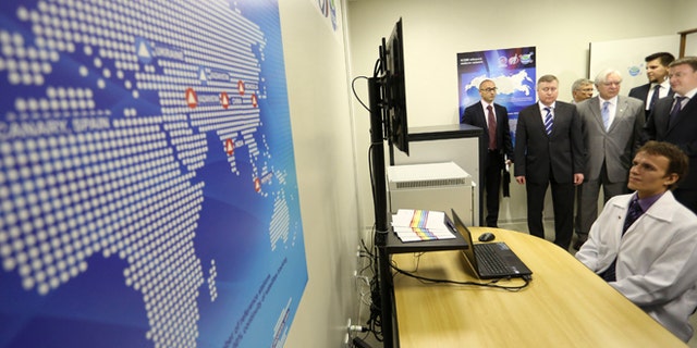 Russian Federal Space Agency (ROSCOSMOS) deputy head Sergey Saveliev (2nd L) and Brazilian Space Agency head Jose Raimundo Coelho (4th L, light suit) preside over the inauguration of the first monitoring station of Russia's GLONASS global navigation system outside of Russia, on the University of Brasilia campus in Brasilia February 19, 2013.