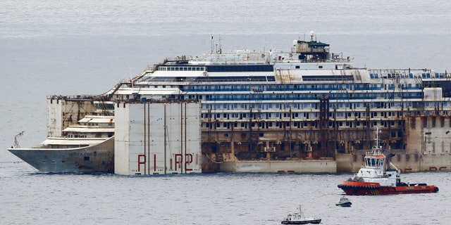 July 27, 2014 - FILE photo of tug boats towing the Costa Concordia ship outside Genoa's port, in northern Italy, where the ship is being broken up for scrap. The company dismantling the ship says workers have discovered human remains believed to be that of the last missing crew member.