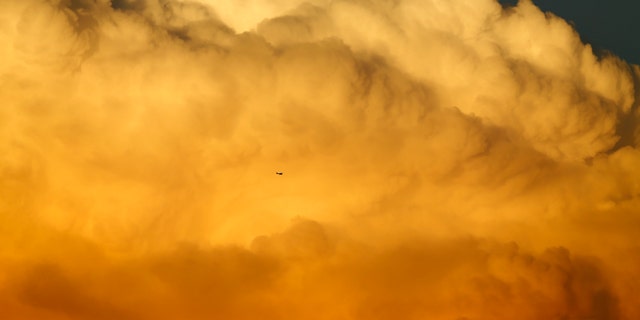A small aircraft flies past a large emerging thunderstorm during sunset near Encinitas, California September 8, 2014. REUTERS/Mike Blake (UNITED STATES - Tags: TRANSPORT ENVIRONMENT SOCIETY TPX IMAGES OF THE DAY) - RTR45GCO