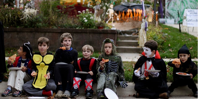 Oct. 31, 2014: Children dressed in costumes eat pizza on Halloween.