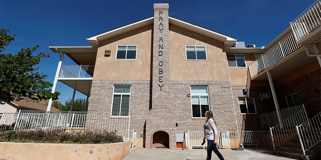 Briell Decker, the 65th wife of jailed Fundamentalist Church of Jesus Christ of Latter-Day Saints (FLDS Church) polygamist prophet leader Warren Jeffs, walks past an outdoor chimney marked with "Pray and Obey" at the compound where he lived for several years, in Hildale, Utah, U.S., May 3, 2017. She is in the process of purchasing the compound. Picture taken May 3, 2017.