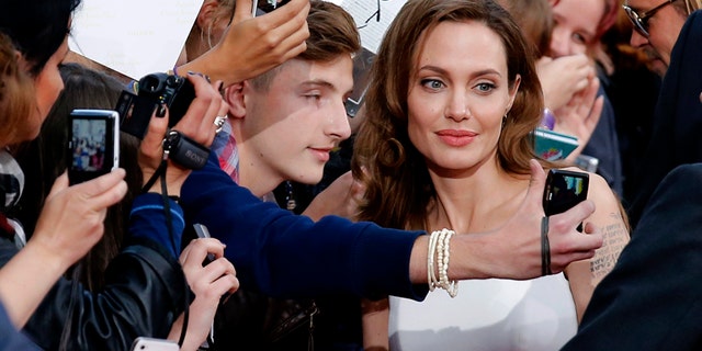 Angelina Jolie (C) poses for a selfie with a fan during the premiere of the film World War Z in Berlin June 4, 2013.