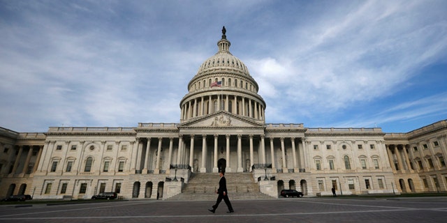 A lone worker passes by the U.S. Capitol building in Washington, October 8, 2013.