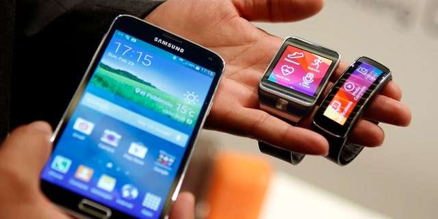 New Samsung Galaxy S5 smartphone (L), Gear 2 smartwatch (C) and Gear Fit fitness band are displayed at the Mobile World Congress in Barcelona.