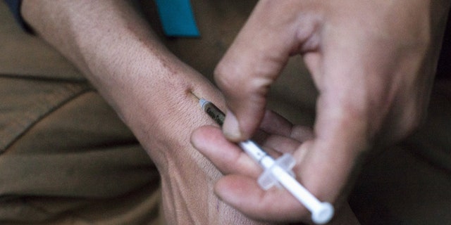 May 14, 2015: A man injects himself with heroin using a needle.