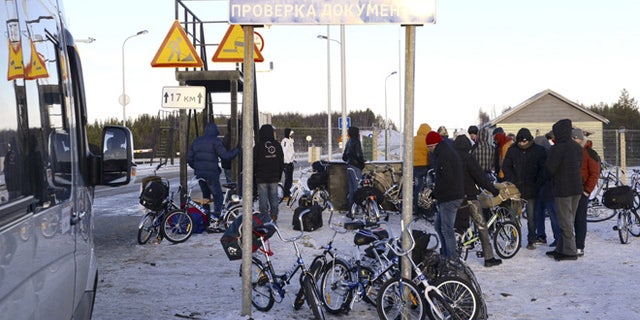 Oct. 30, 2015: Refugees and migrants gather near a check point on the Russian-Norwegian border.