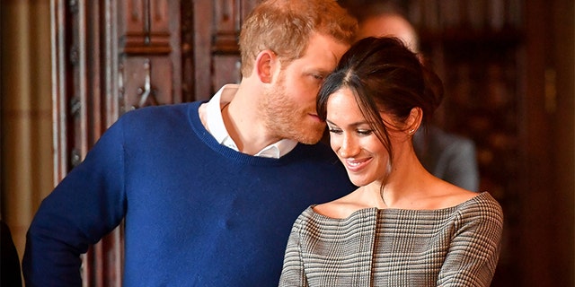 Britain's Prince Harry whispers to Meghan Markle as they watch a performance by a Welsh choir in the banqueting hall during a visit to Cardiff Castle in Cardiff, Britain, January 18, 2018.