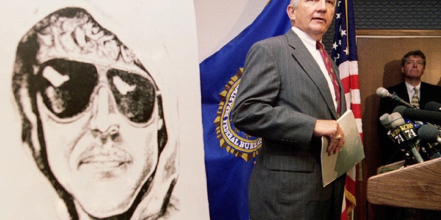 FBI Special Agent in Charge Jim Freeman confirms to reporters the authenticity of the most-recent communication from the notorious Unabomber, seen in a composite photo at left, during a press conference in San Francisco, June 28. The Unabomber has threatened to bomb an airliner leaving Los Angeles in the next six days - RTXFWC0