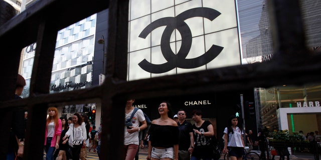 Shoppers walk across Canton Road, famous for its luxury brand stores, at Hong Kong's Tsim Sha Tsui shopping district May 9, 2013. Armed with empty suitcases and same-day return tickets, an army of mainland Chinese is descending on suburban outlet shopping malls and international fashion chains in Hong Kong, turning cheap into the new chic as luxury falls out of favour. Picture taken May 9, 2013. To match HONGKONG-RETAILERS/ REUTERS/Bobby Yip (CHINA - Tags: BUSINESS) - RTXZTB2