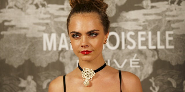 Cara Delevingne poses for photographers at the Chanel 'Mademoiselle Prive' exhibition, in London, Britain, on October 12, 2015.