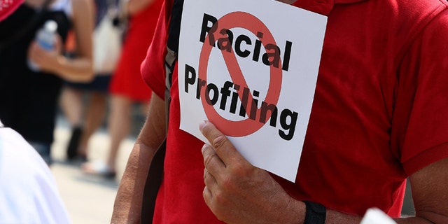 WASHINGTON - JULY 07: A man holds a sign against racial profiling during a protest with Community and faith leaders from Arizona in front of the White House on July 7, 2010 in Washington, DC. Activists plan a 24-hour vigil outside the White House to protest the imminent new immigration law in Arizona. (Photo by Mark Wilson/Getty Images)