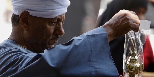 An Egyptian buys traditional Ramadan lantern marking the holy month of Ramadan at a market in the neighborhood of Sayeda Zeinab, Cairo, Egypt, Thursday, June 26, 2014. Muslims observe the dawn-to-dusk fasting during the holy month of Ramadan starting next week.