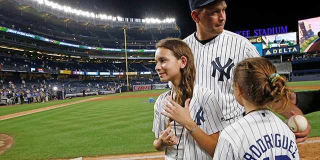 New York Yankees designated hitter Alex Rodriguez (13) gathers his daughters, Natasha, left, and Ella, before leaving the field after his final baseball game as a Yankee player, against the Tampa Bay Rays at Yankee Stadium in New York, Friday, Aug. 12, 2016. The Yankees won 6-3. (AP Photo/Kathy Willens)