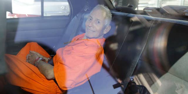 FILE - In this March 2015, file photo, Robert Durst is transported from Orleans Parish Criminal District Court to the Orleans Parish Prison after his arraignment in New Orleans. Durst was indicted Wednesday, April 8, on the two weapons charges that have kept him in New Orleans even though his lawyers say he wants to go to Los Angeles as soon as possible to face a murder charge. (AP Photo/Gerald Herbert, File)