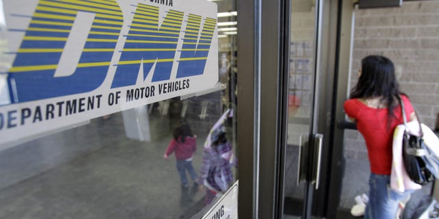 FILE - In this June 30, 2011 file photo, a customer walks into a Department of Motor Vehicles office in Redwood City, Calif. The U.S. Department of Homeland Security has granted a last-minute extension giving the state of California more time to comply with a federal Real ID Act, which sets stricter standards on identification. The state Department of Motor Vehicles announced Wednesday, Dec. 30, 2015, that the federal agency would have until Oct. 10, 2016 to comply with the rules. (AP Photo/Paul Sakuma, File)