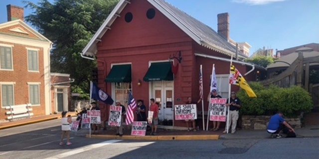 People gathered in front of The Red Hen to protest on the day of its reopening.