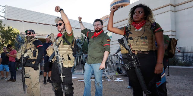 Members of the John Brown Gun Club and Redneck Revolt protest outside the Phoenix Convention Center, Tuesday, Aug. 22, 2017, in Phoenix. Protests were held against President Trump as he hosted a rally inside the convention center. (AP Photo/Matt York)