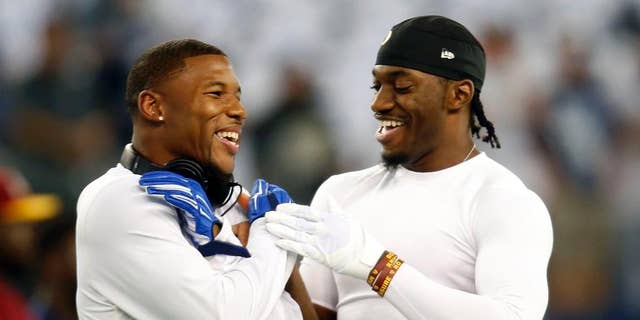 Dallas Cowboys wide receiver Terrance Williams, left, and Washington Redskins quarterback Robert Griffin III, right, greet each other on the field during warm ups before an NFL football game, Monday, Oct. 27, 2014, in Arlington, Texas. Williams and Griffin III played at Baylor University as teammates before entering the NFL. (AP Photo/Tim Sharp)