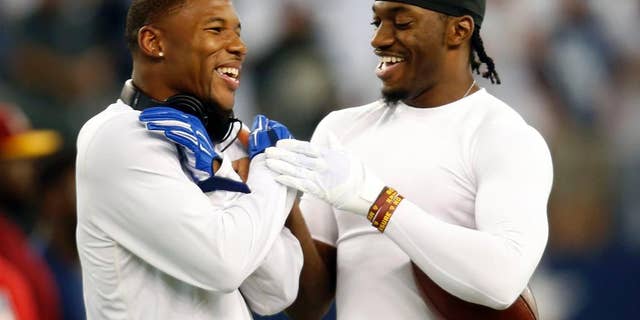 Dallas Cowboys wide receiver Terrance Williams, left, and Washington Redskins quarterback Robert Griffin III, right, greet each other on the field during warm ups before an NFL football game, Monday, Oct. 27, 2014, in Arlington, Texas. Williams and Griffin III played at Baylor University as teammates before entering the NFL. (AP Photo/Tim Sharp)