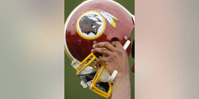 FILE - In this May 1, 2009 file photo, Washington Redskins Marko Mitchell puts his helmet on during their NFL football minicamp practice at their training facility in Ashburn, Va. Half of the U.S. Senate says it's time to change the name of the Washington Redskins. Forty-nine Democratic senators wrote NFL Commissioner Roger Goodell on Thursday, May 22, 2014. They say racism and bigotry do not belong in professional sports. (AP Photo/Alex Brandon, File)