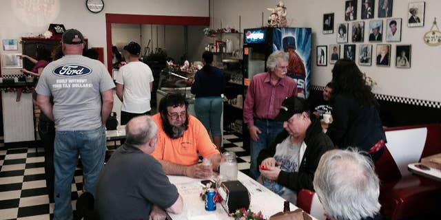 Many customers wait for service as Memories Pizza reopened for business Thursday, April, 9, 2015, in Walkerton, Ind. The restaurant was closed, and its operators said they'd gone into hiding after their comment that they would not serve pizza to a gay wedding prompted an avalanche of criticism on social media. Facing widespread pressure, including from big businesses, Indiana's Republican-controlled Legislature rolled back their states' new religious objections laws, which critics said could be used to discriminate against gays. (AP Photo/Tom Coyne)
