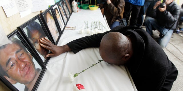 April 10: Efanye Chibuko touches a picture of his wife Doris during a memorial at Oikos University in Oakland, California. Doris Chibuko was among the victims of a shooting rampage at the Oakland school.